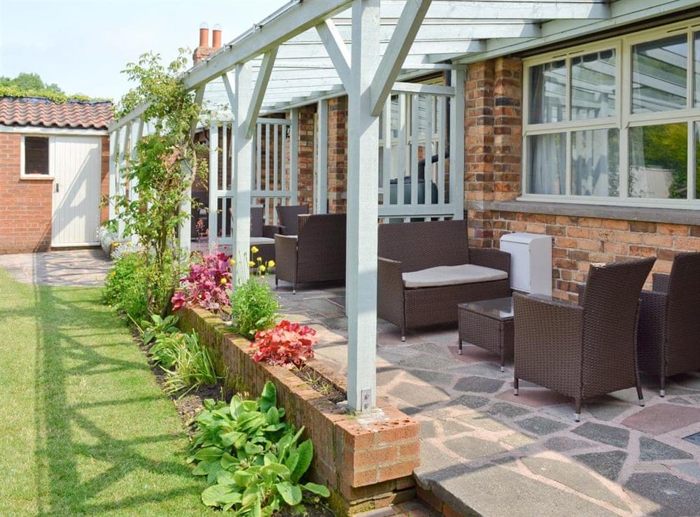 Covered patio with outdoor furniture at Jasmine Cottage in Scarborough, North Yorkshire