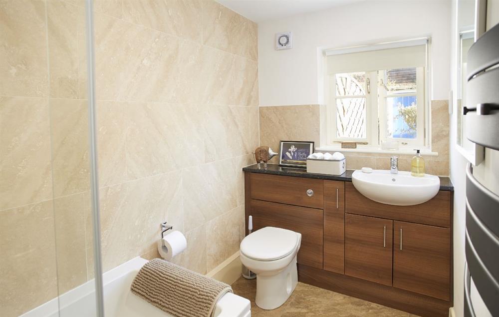 Bathroom with bath and shower overhead at Jasmine Cottage, South Wingfield near Crich