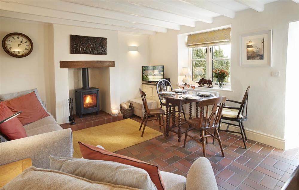 Sitting room with cosy wood burner and dining table at Jasmine Cottage, South Wingfield near Crich