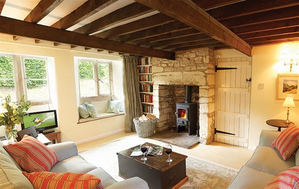 Ground floor: Sitting room with wood burning stove at Jasmine Cottage, Windrush