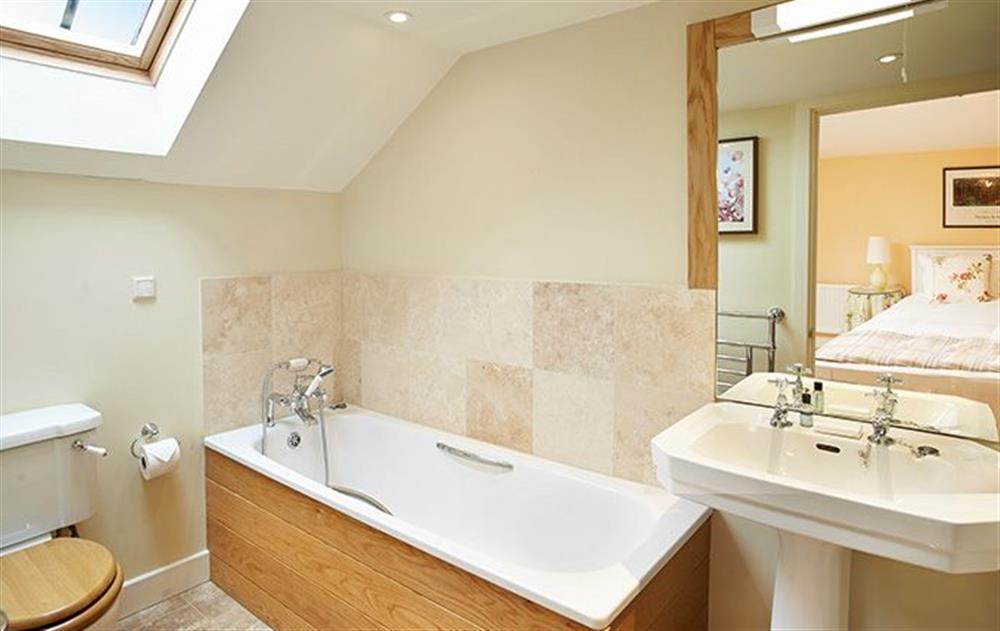 En-suite bathroom with a cast iron bath with shower on riser at Jennys Croft, Glassonby