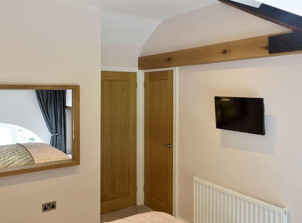 Peaceful double bedroom with wall-mounted TV at Joiners Cottage in Ingmire Hall, near Sedbergh, Cumbria