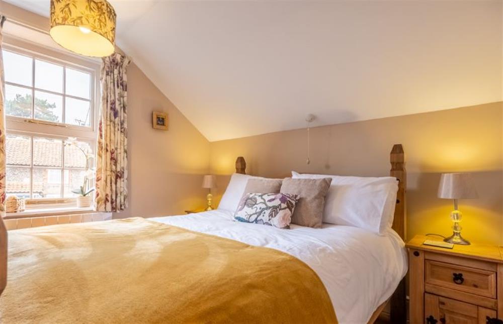 Master bedroom in the eaves, with a double bed at Jollyboat Cottage, Blakeney near Holt