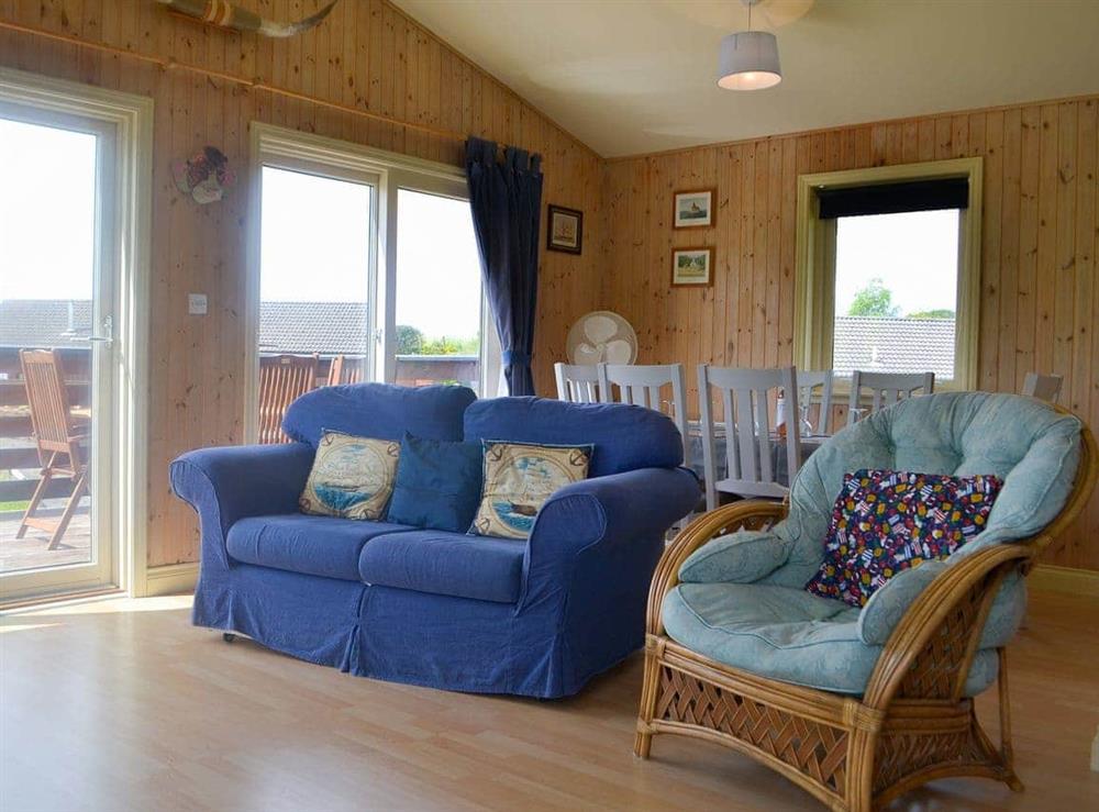 Cosy and comfortable living space with patio doors to the decked area at Kaptains Cabin in Yanwath, near Penrith, Cumbria