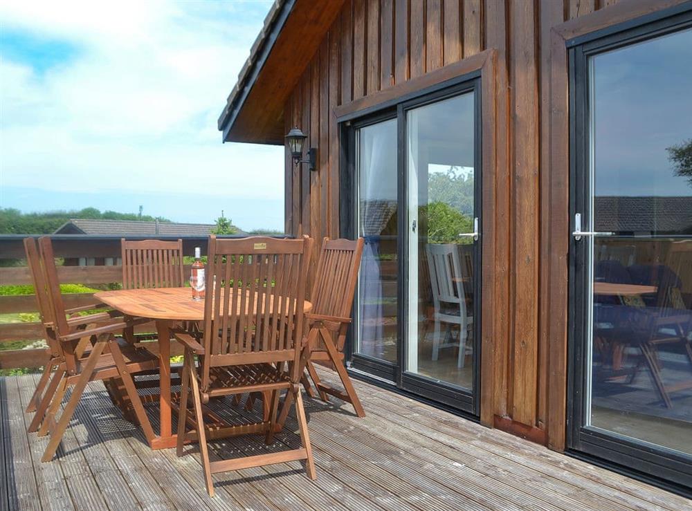 Decked area with table and chairs at Kaptains Cabin in Yanwath, near Penrith, Cumbria