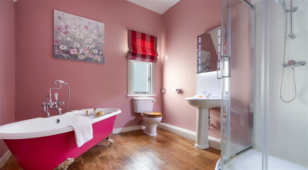 The bathroom with roll-top bath and freestanding shower at Kedleston Park House in Derby, Derbyshire