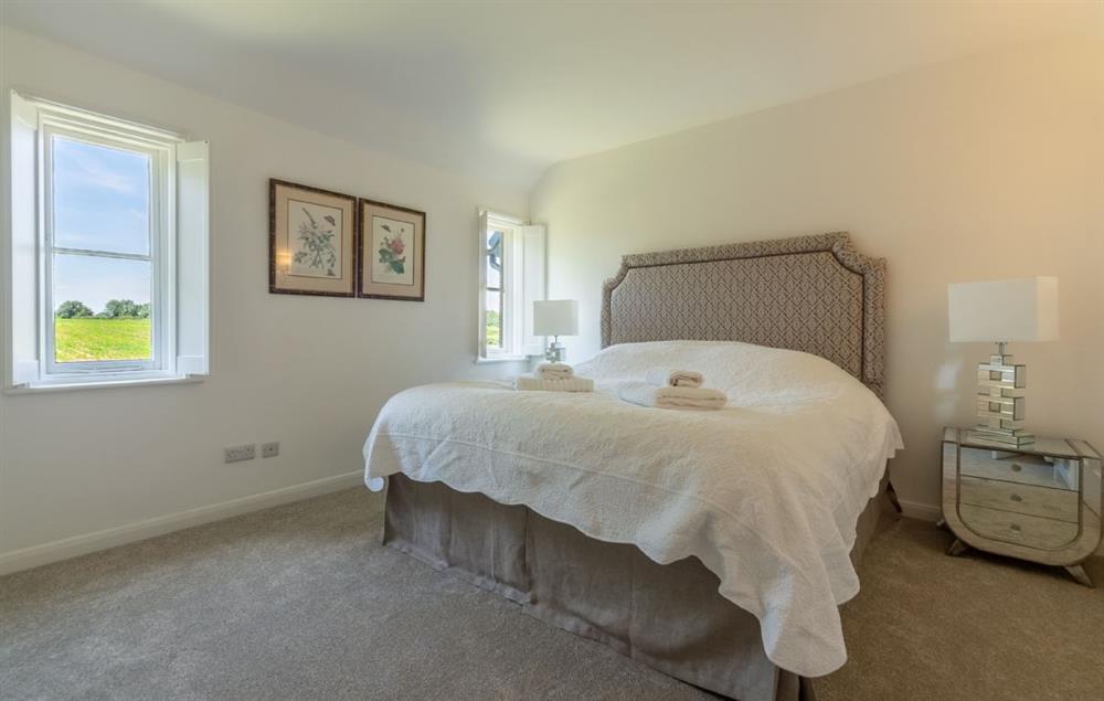 Spacious bedroom with 6’ super-king size bed and en-suite shower room at Keepers Cottage, Middleton