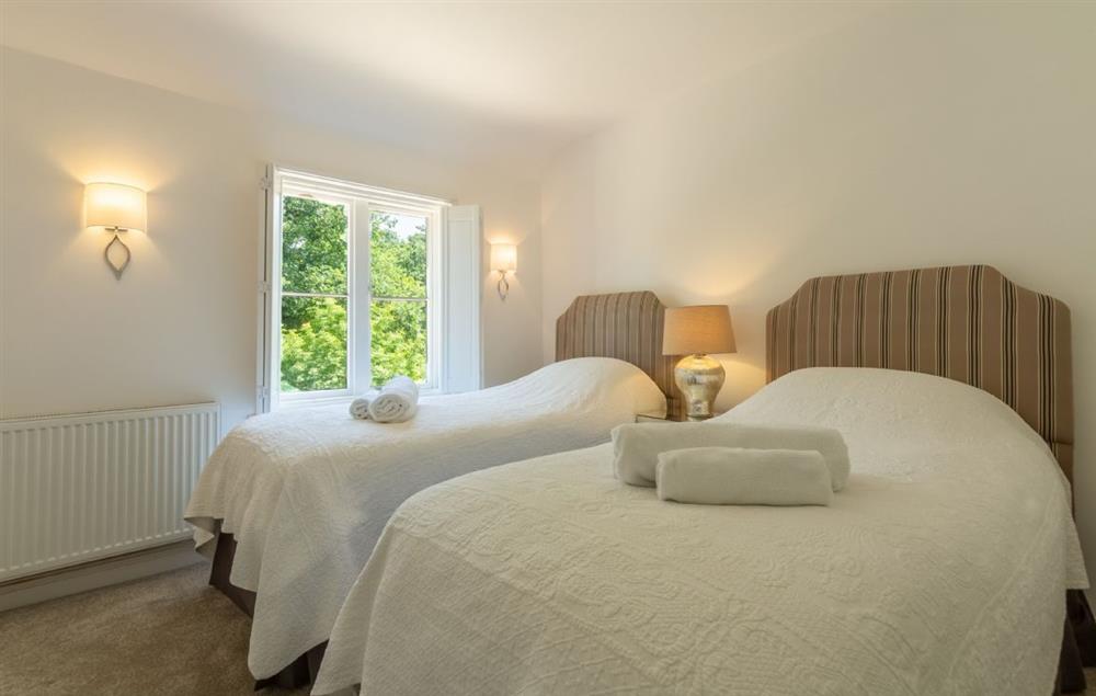 Twin bedroom with 3’ single beds and en-suite bathroom at Keepers Cottage, Middleton