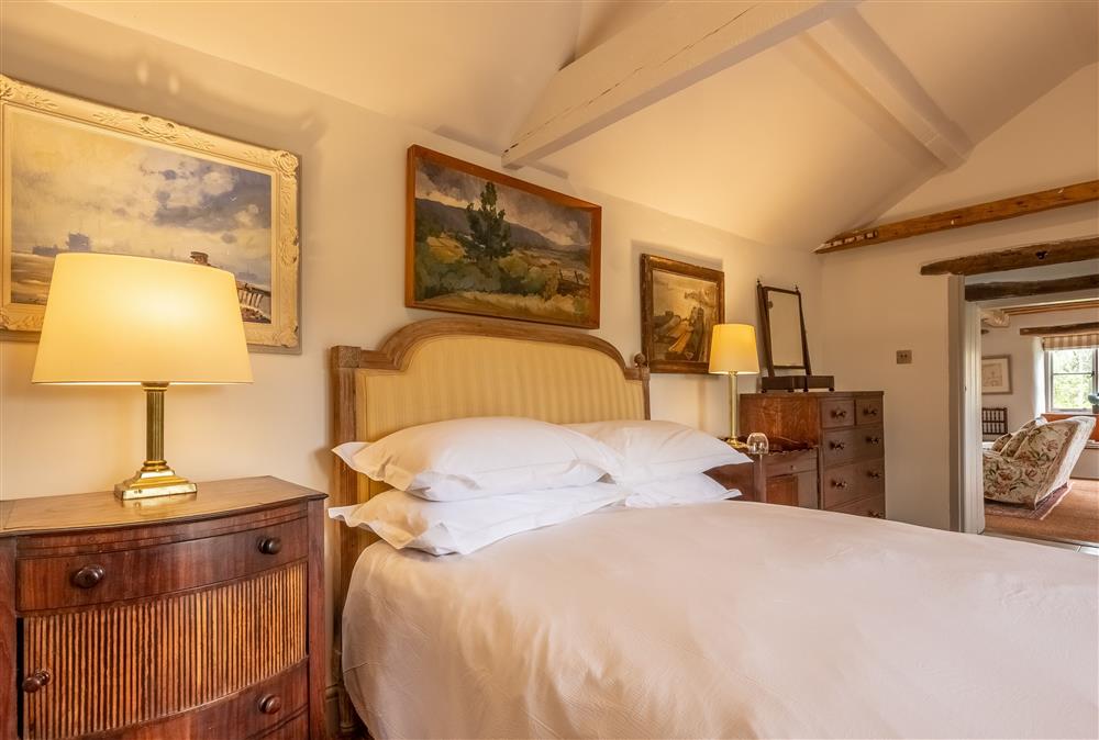 Bedroom one with a 6’ super-king size bed and en-suite shower room at Keepers Cottage, Wolterton