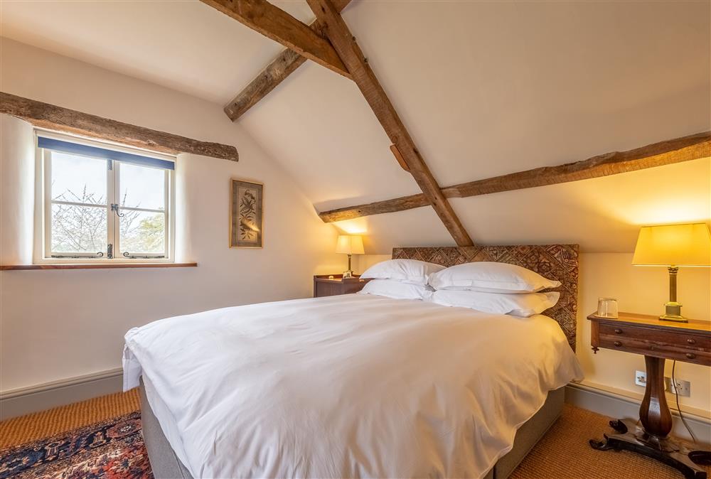 Bedroom three with a 5’ king-size bed and exposed beams (photo 2) at Keepers Cottage, Wolterton