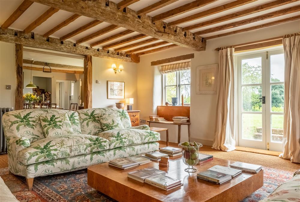 Sitting room enjoys wonderful views of the surrounding parkland, and exposed beams at Keepers Cottage, Wolterton