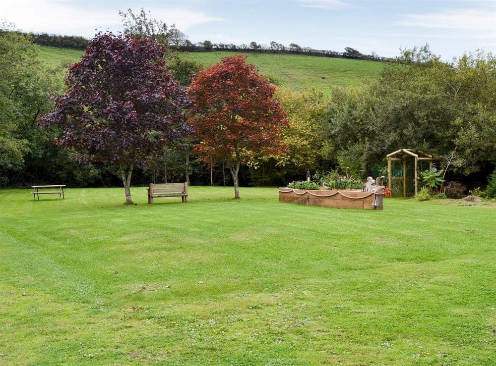 Large lawned garden with sitting-out area and garden furniture at Bluebell, 