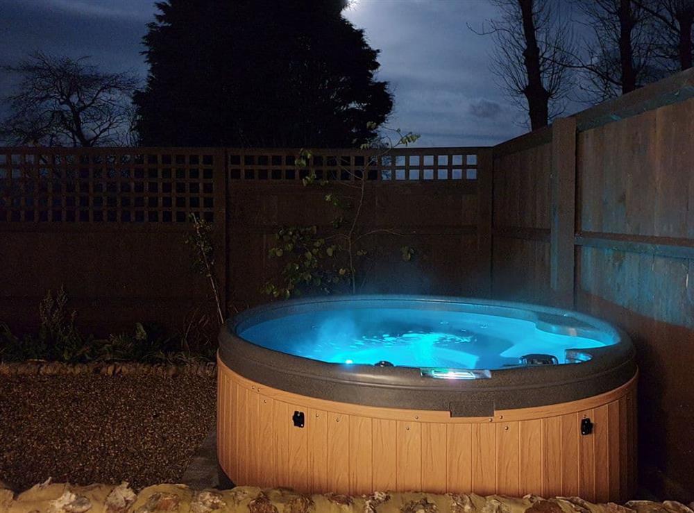 Hot tub lit up at night at The Stables, 