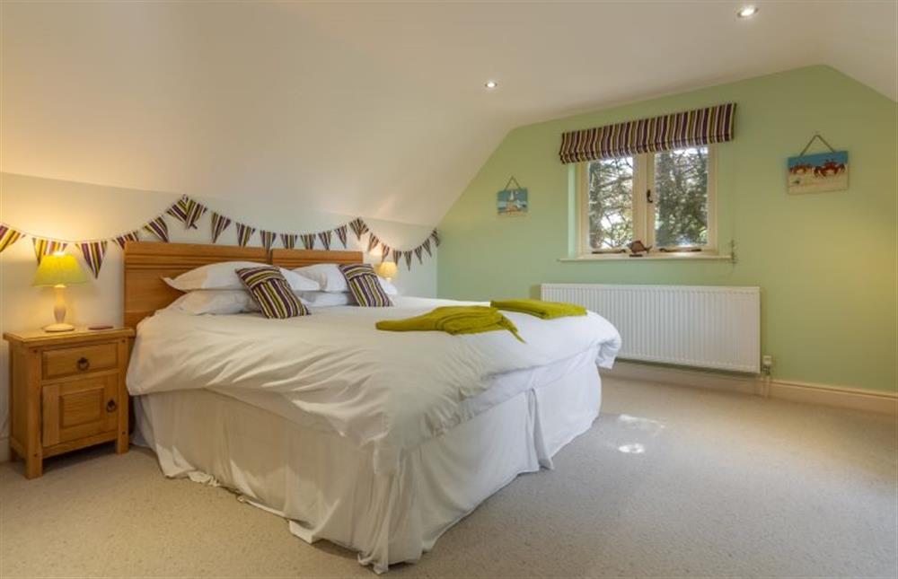 First floor: Bedroom two has a king-size bed at Kittiwake Cottage, Brancaster near Kings Lynn