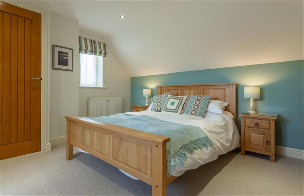 First floor: The master bedroom has a king-size bed at Kittiwake Cottage, Brancaster near Kings Lynn