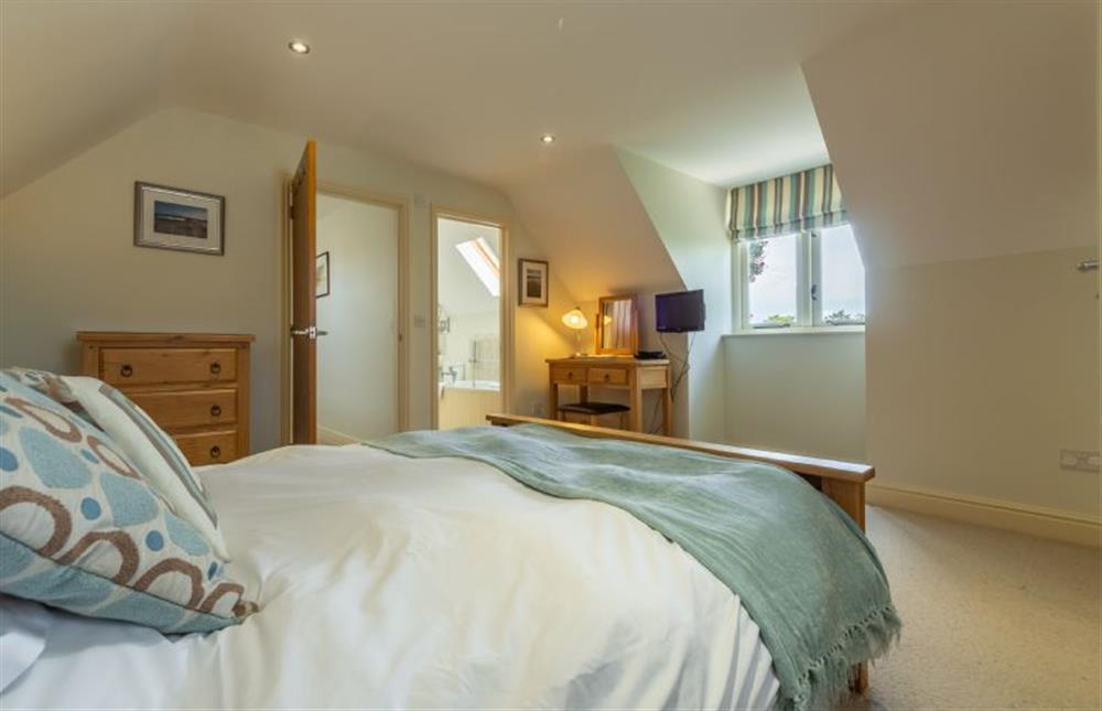 First floor: The master bedroom has an en-suite bathroom at Kittiwake Cottage, Brancaster near Kings Lynn