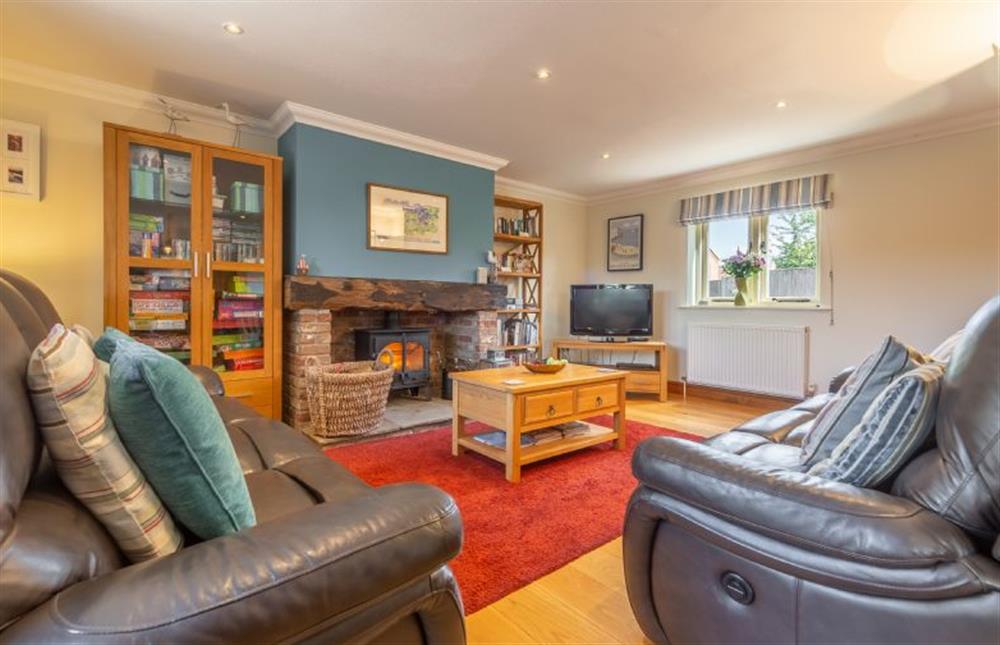 Ground floor: Sitting room with reclining leather sofas and wood burning stove at Kittiwake Cottage, Brancaster near Kings Lynn