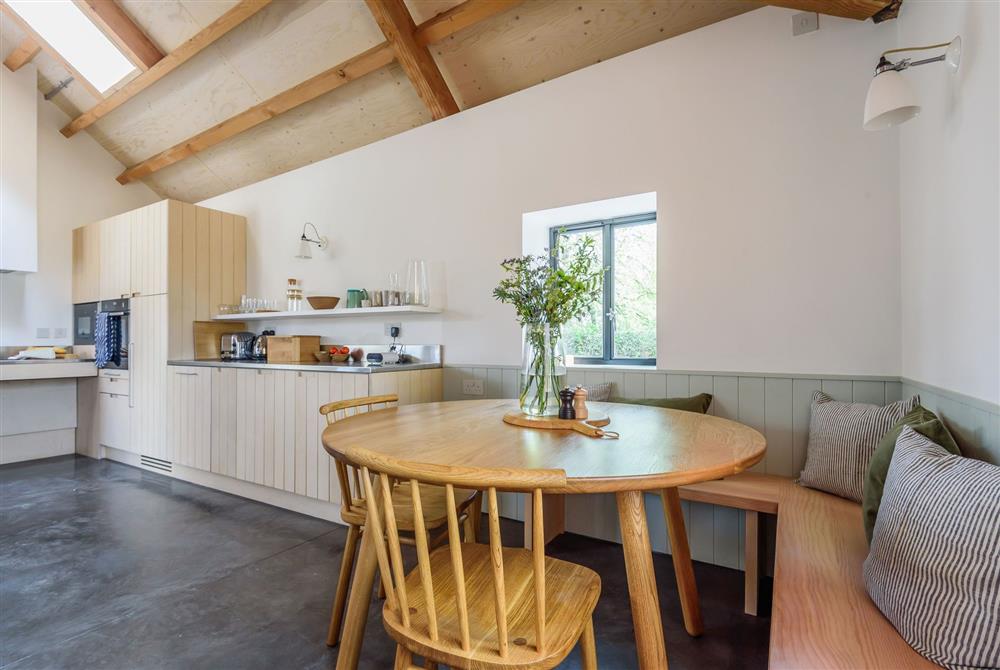 The dining area and contemporary kitchen with exposed beams throughout at Kittwhistle, Dorchester