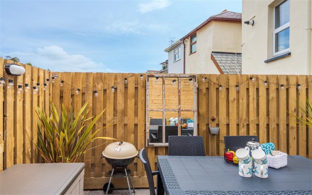 Well-presented and furnished rear patio with bbq and trendy evening lighting.  at Knott Cottage in Dartmouth