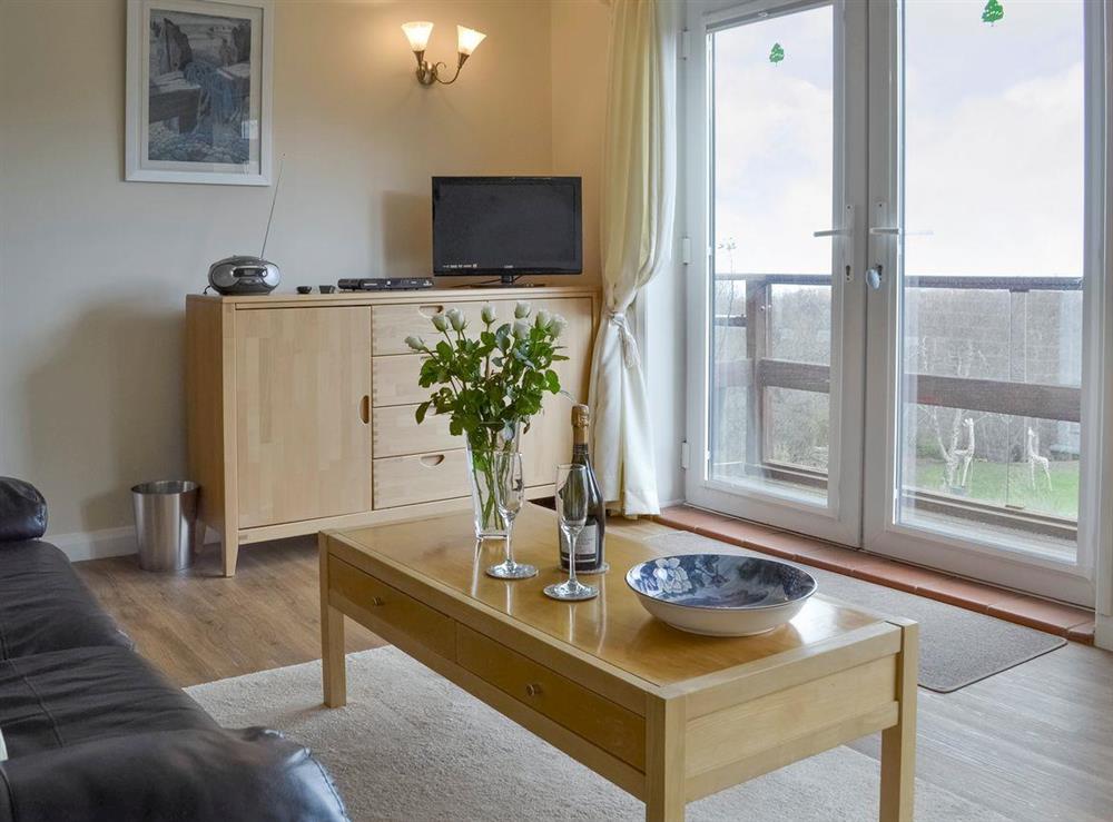 Attractive living room with French doors to balcony at Knowle Croft Cottage in Fairlight, near Hastings, East Sussex