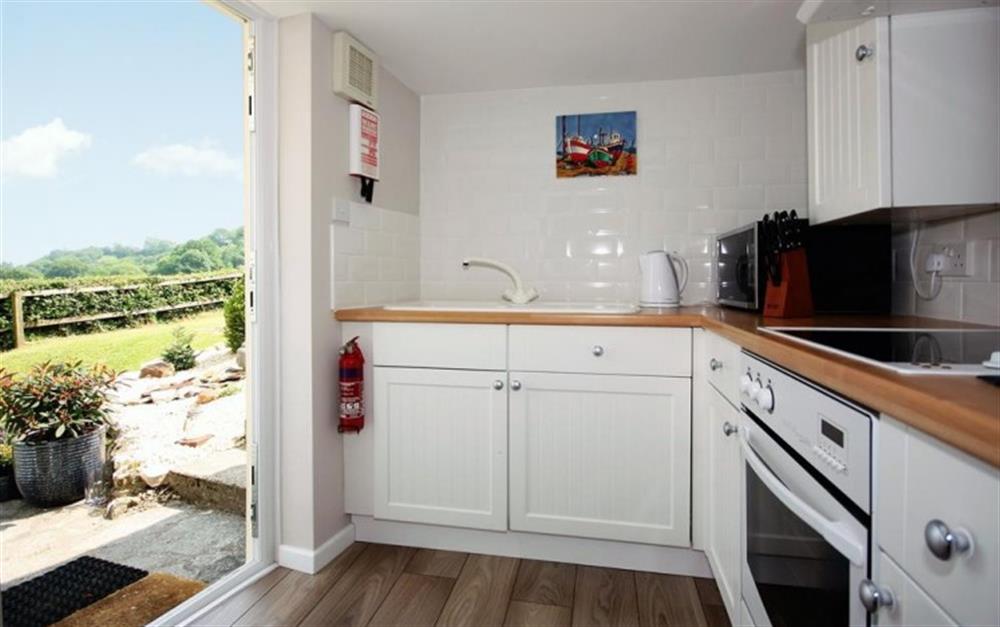 The fitted kitchen with direct access to the garden at Kowhai Cottage in Charmouth