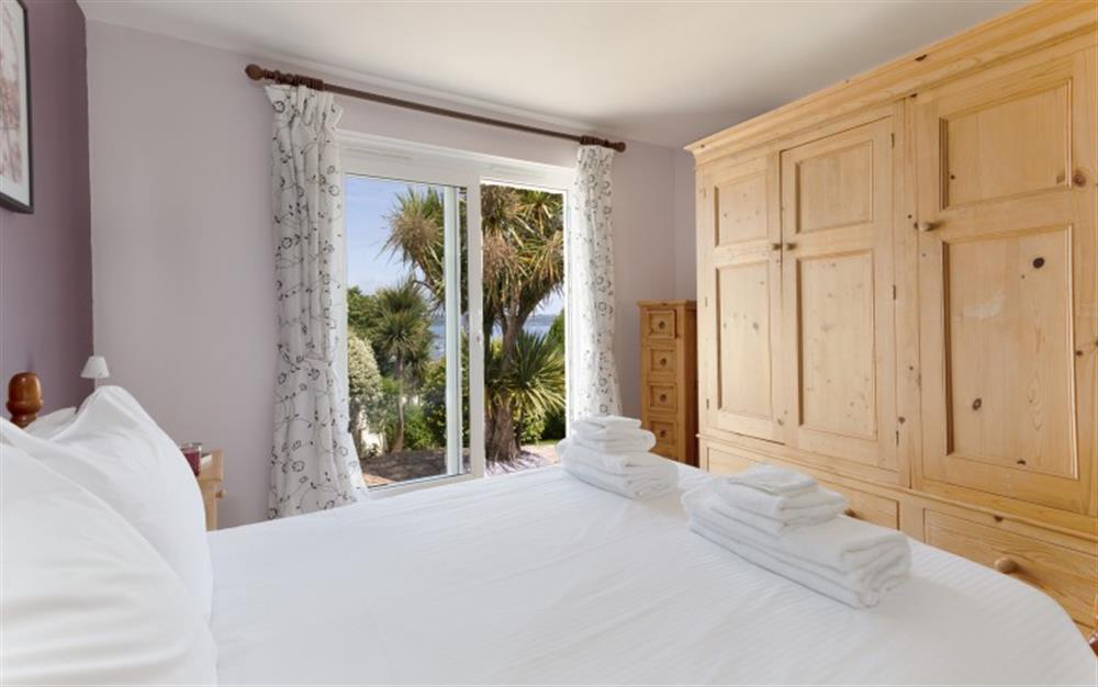 The downstairs double bedroom has patio doors to the garden. at La Mouette in Falmouth