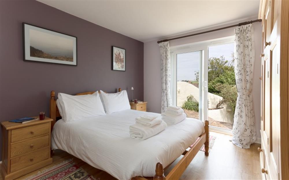The second bedroom is downstairs and has doors opening onto the patio. at La Mouette in Falmouth