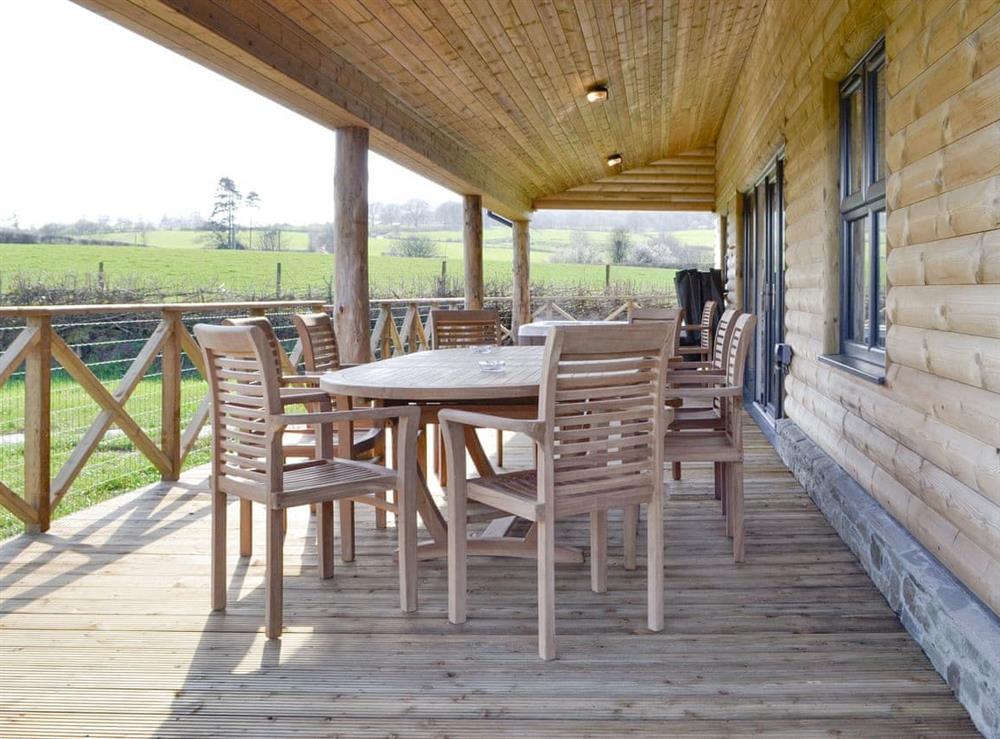 Decked area with outdoor furniture and hot tub at Lakeside Lodge in near Rhayader, Powys