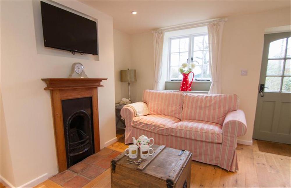 Ground floor:  Sitting area with comfy sofa and decorative fireplace and flatscreen television at Lambert Cottage, Snettisham near Kings Lynn