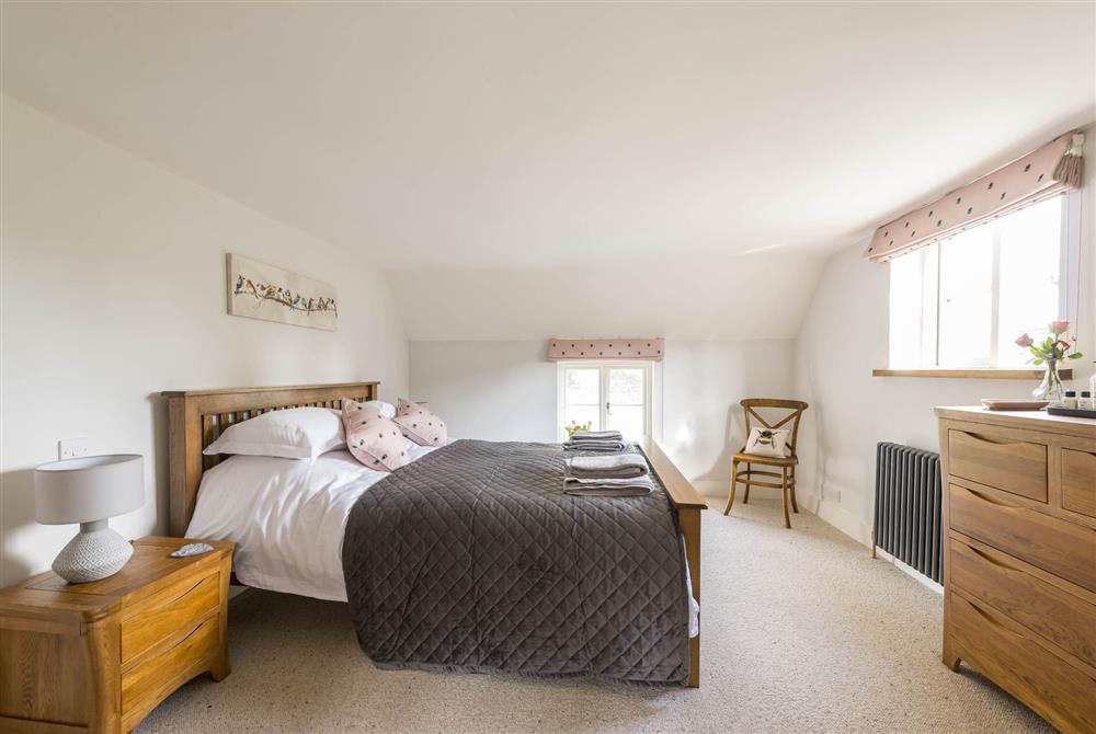 Master bedroom with king-size bed and en-suite bathroom at Lanes End Cottage, Dorchester