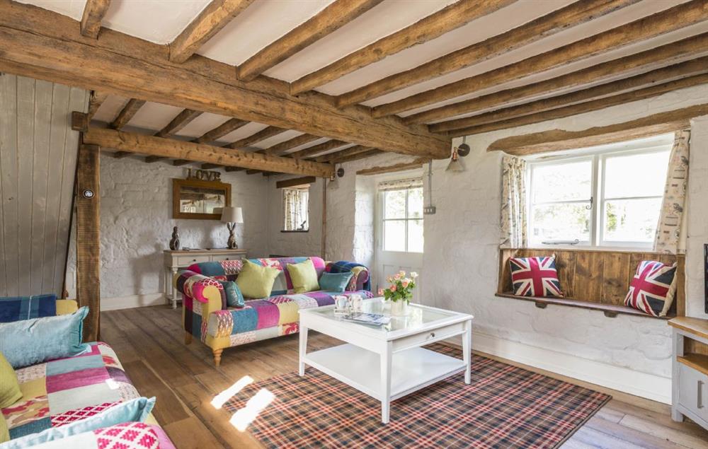 Spacious sitting room with open fire and exposed beams