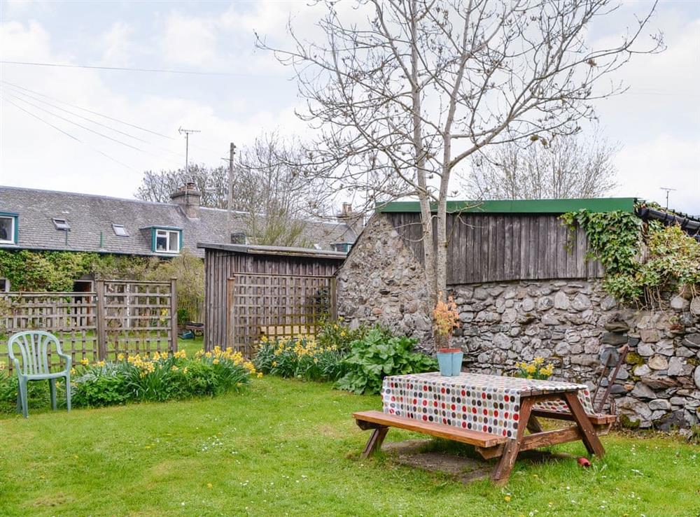Enclosed lawned garden with sitting out area at Larch Cottage in Kirkmichael, near Pitlochry, Perthshire