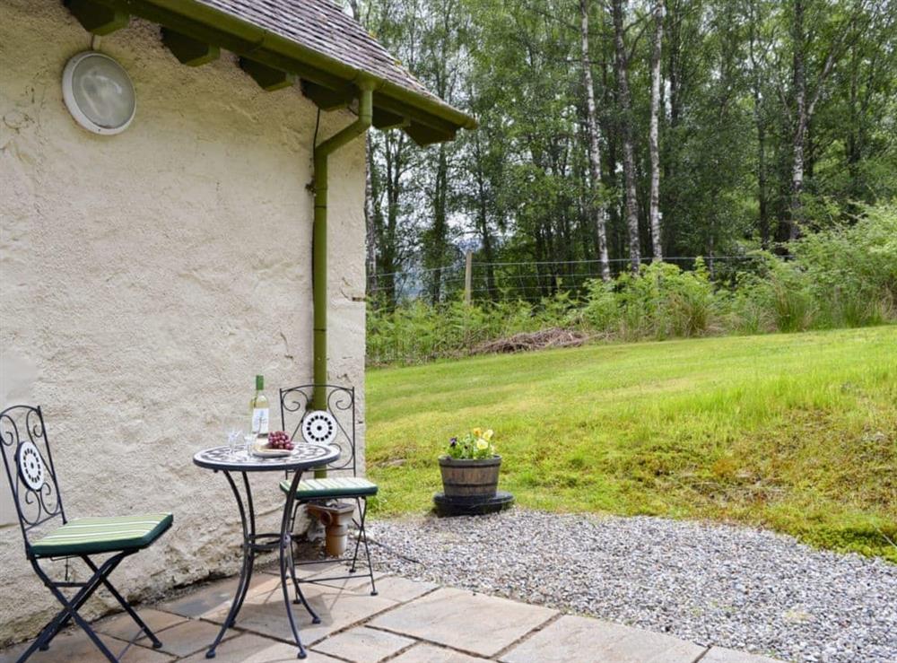 Lawned garden with patio and furniture at Laundry Cottage in Ceannacroc, Inverness-shire. , Inverness-Shire