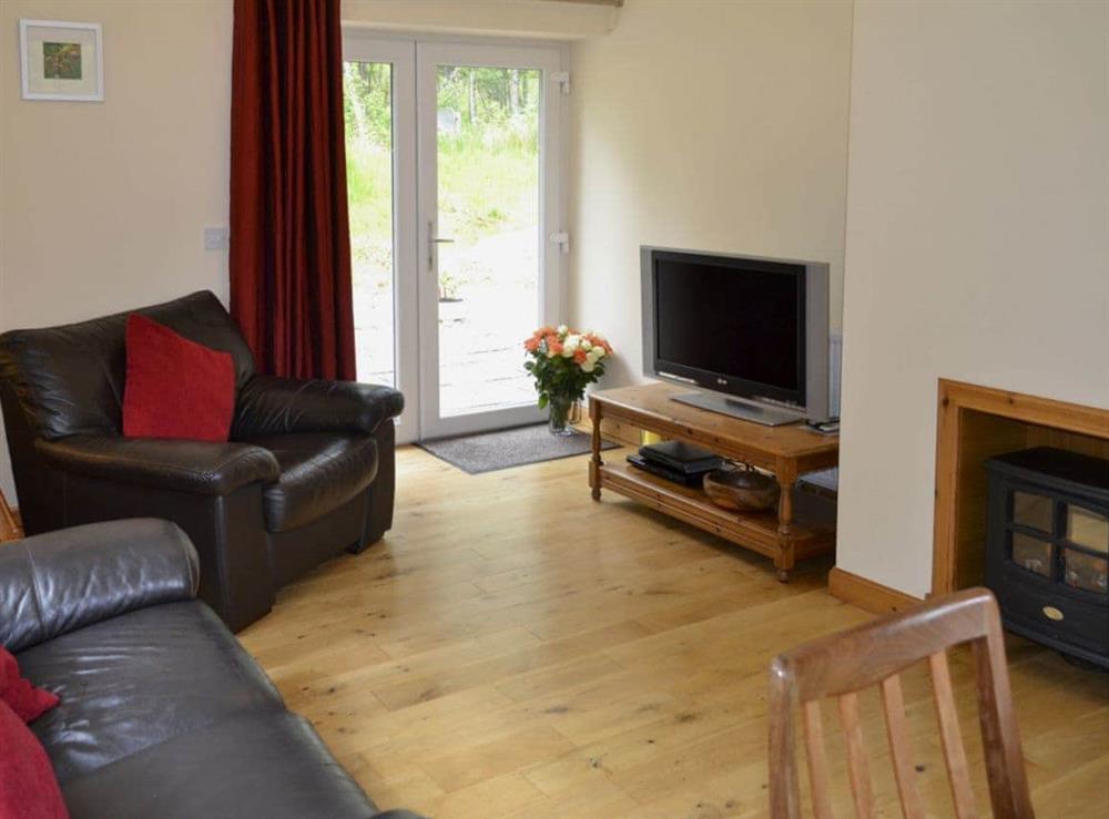 Spacious living/dining room with electric woodburner and wooden floor at Laundry Cottage in Ceannacroc, Inverness-shire. , Inverness-Shire