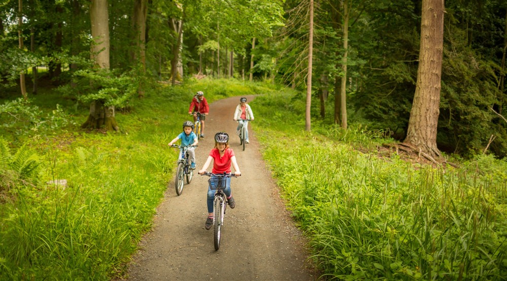 A family cycling on the Dragon Cycle Trail at Laundry Cottage in Morpeth, Northumberland