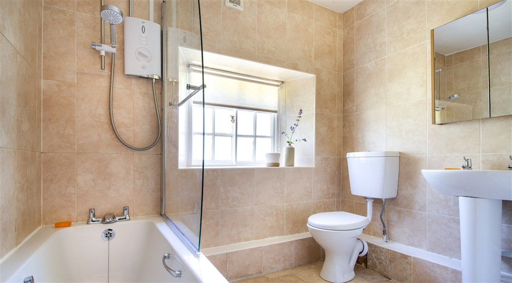 The bathroom, with shower over bath, at Laundry Cottage in Morpeth, Northumberland