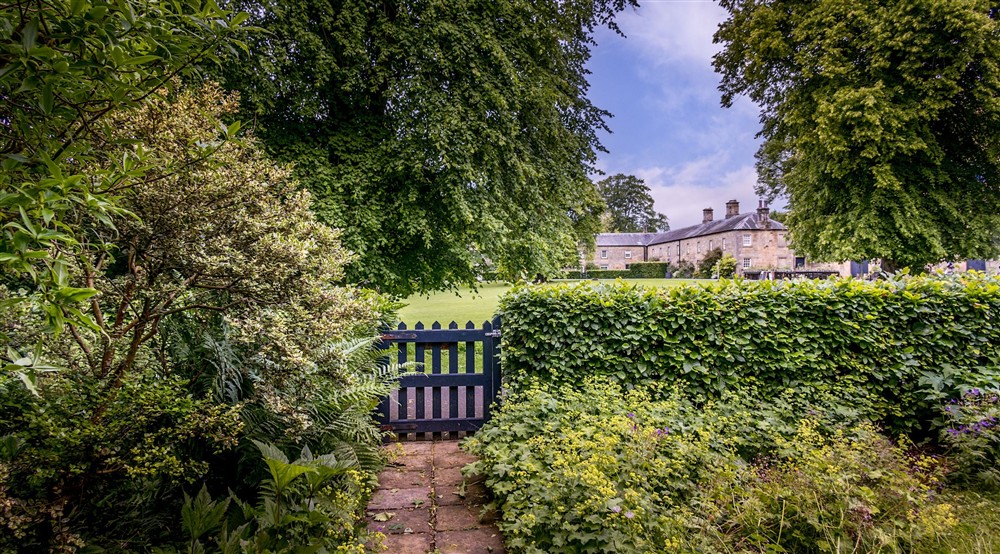 The gate in the front garden opens onto the Wallington estate, Northumberland at Laundry Cottage in Morpeth, Northumberland