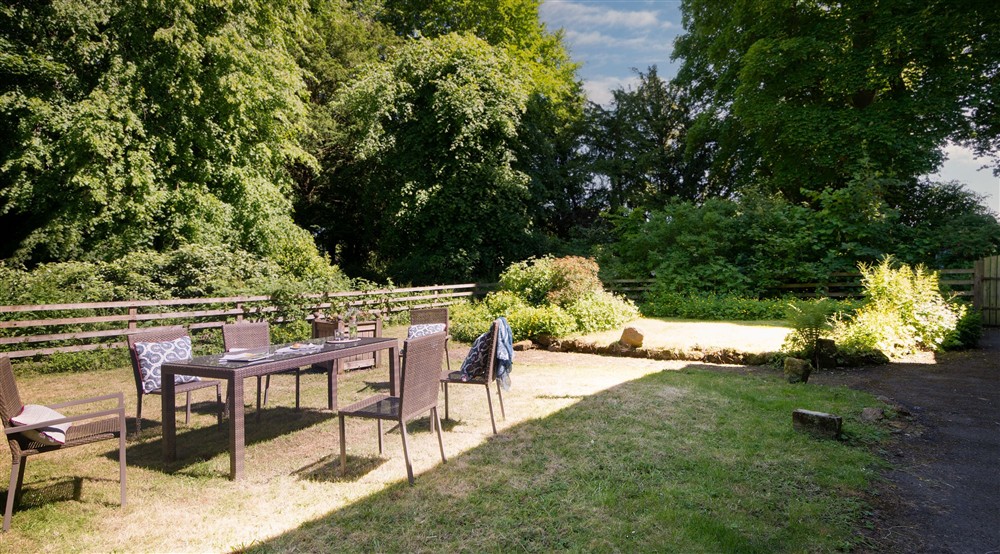 The lawned garden with dining furniture for six at Laundry Cottage in Morpeth, Northumberland