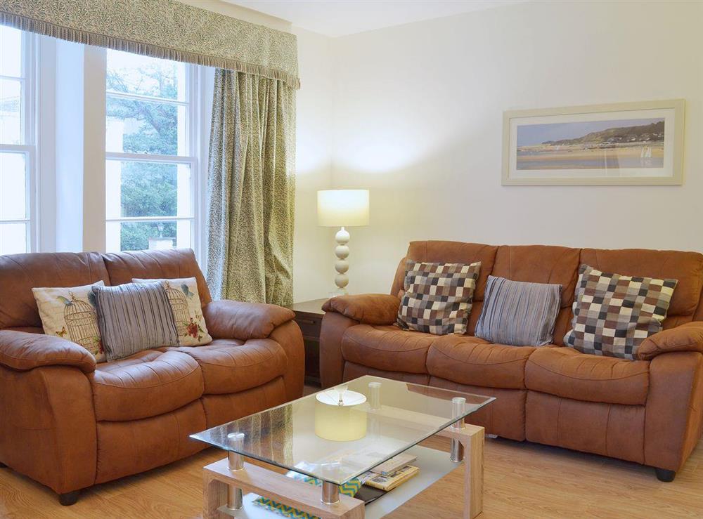 Comfortable elather sofas and contemporary furnishings make the living room a comfortable and relaxing place at Laurel Cottage in Torquay, Devon