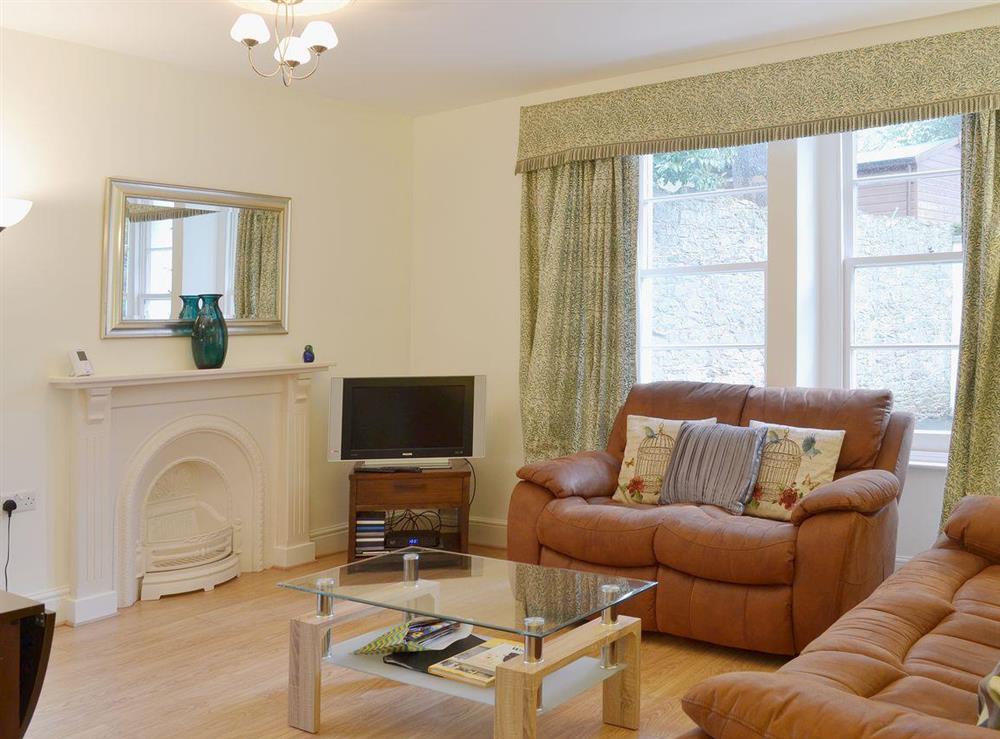 High ceilings and and ornate fireplace give the living room an air of luxury at Laurel Cottage in Torquay, Devon