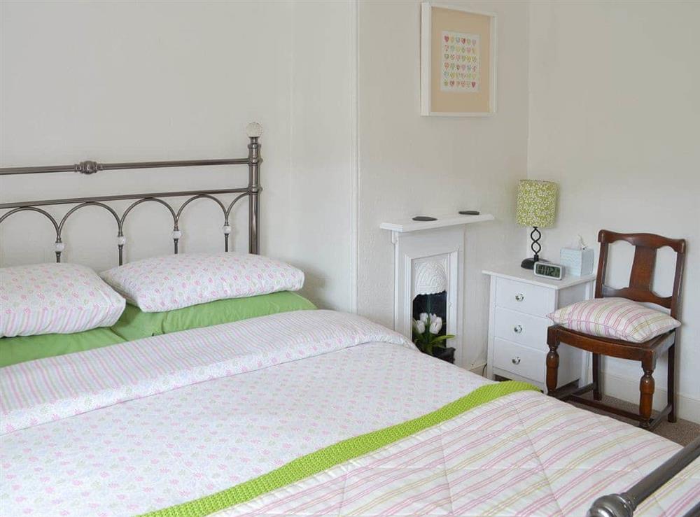 Welcoming double bedroom with antique-style bed at Lavender Cottage in Buckfastleigh, Devon