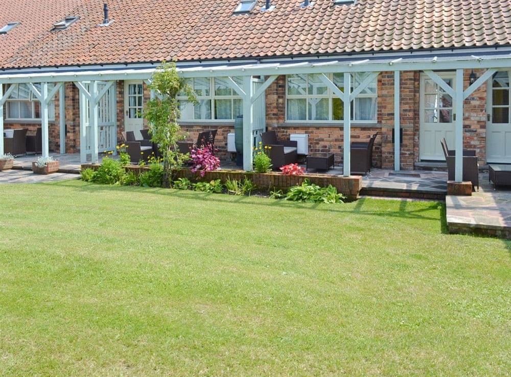 Rear lawned garden with covered patio at Lavender Cottage in Scarborough, North Yorkshire