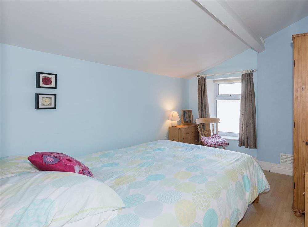 Bedroom with sloping ceiling and double bed at Lazy Cottage in Haverigg, near Millom, Cumbria