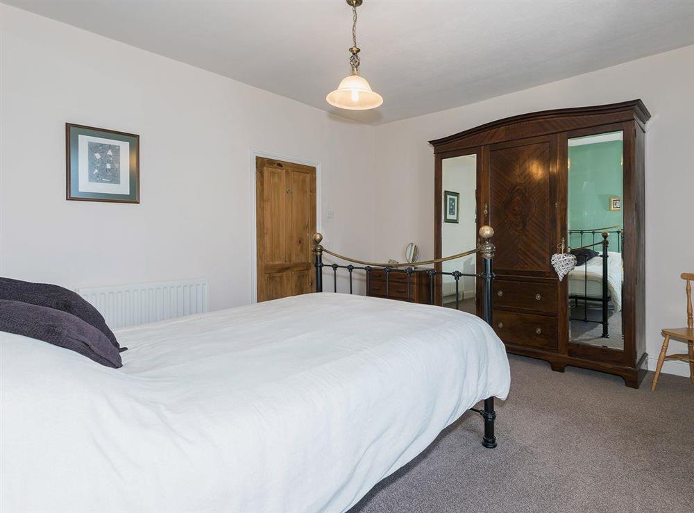 Double bedroom with antique style metal bedstead at Lazy Cottage in Haverigg, near Millom, Cumbria