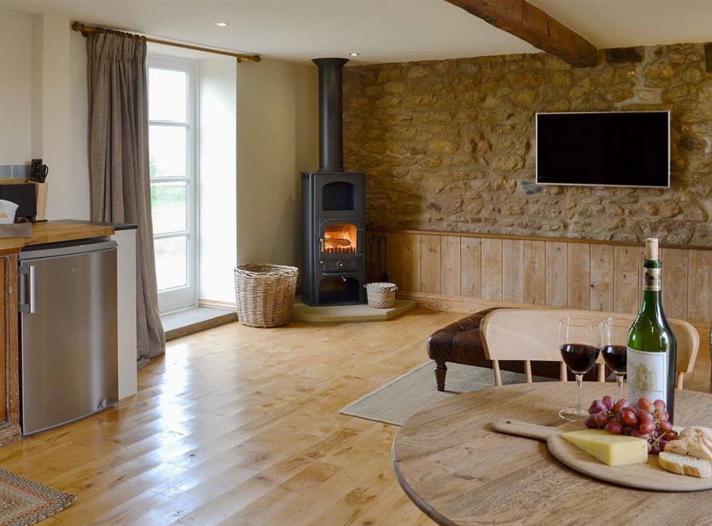 Warm and welcoming open plan living space with wood burner at Bell Cottage, 