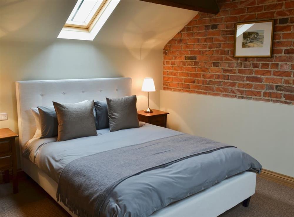 Double bedroom with original exposed brickwork at Mullins Cottage, 