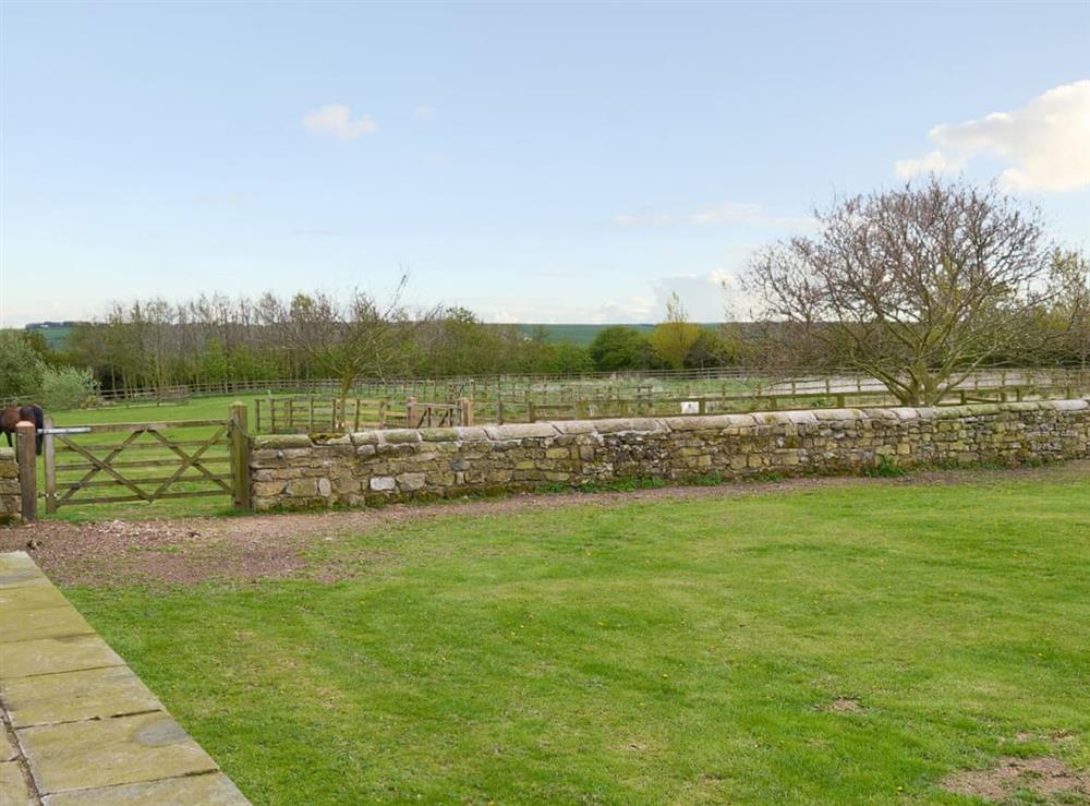 Lawned garden and views over the surrounding rolling countryside at Mullins Cottage, 