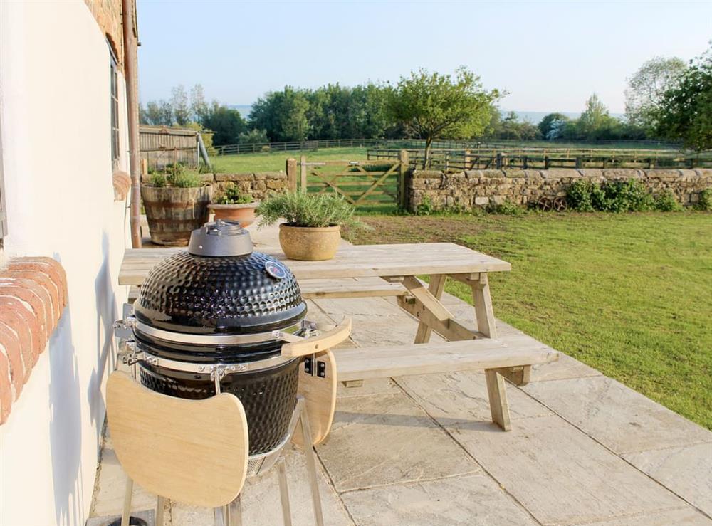 Paved patio with outdoor furniture and BBQ at Mullins Cottage, 