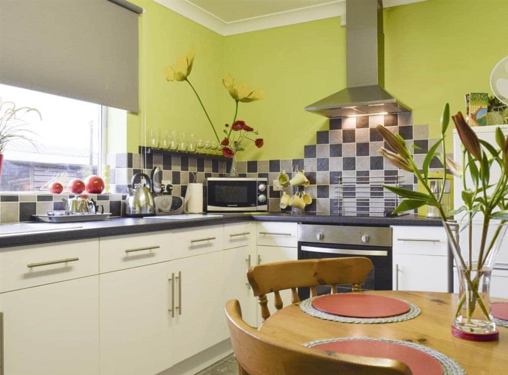 Well-equipped fitted kitchen with dining area at Lenas Lodge in Camer’s Green, Berrow, near Malvern, Worcestershire