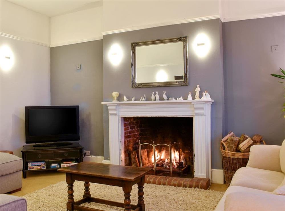 Delightful living room with an open fire at Leygreen Farmhouse in Beaulieu, near Brockenhurst, Hampshire